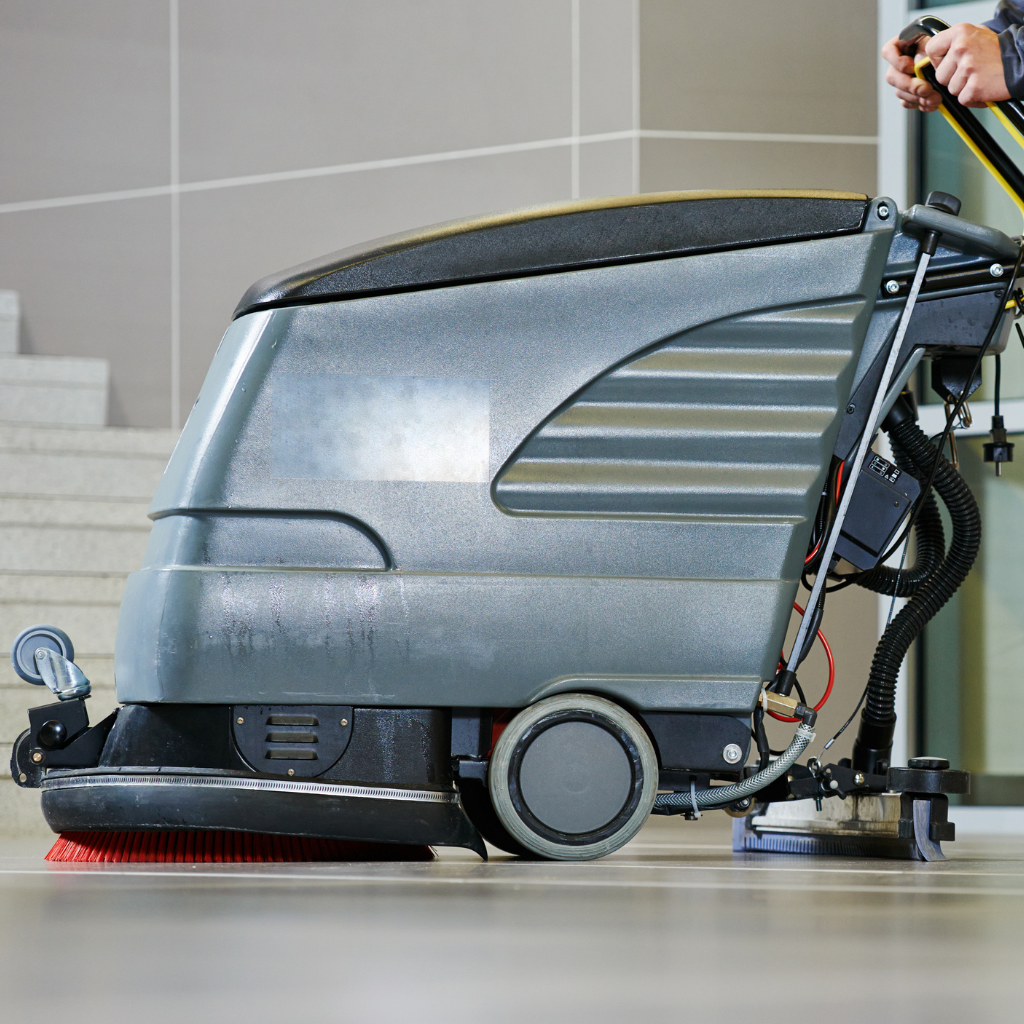 "A mechanical floor cleaner poised for action on a shiny floor."